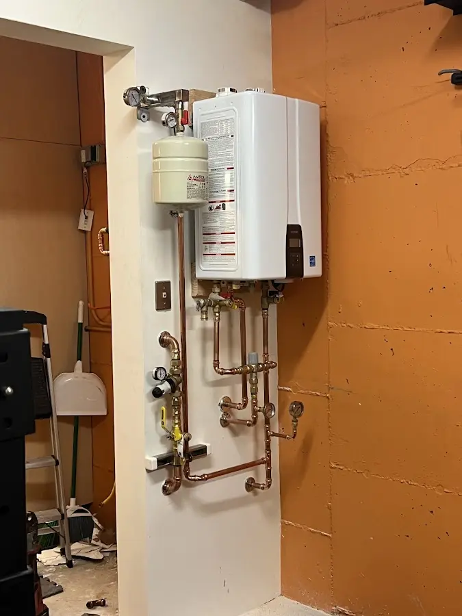 Plumbing technician inspecting water heater connections in San Angelo